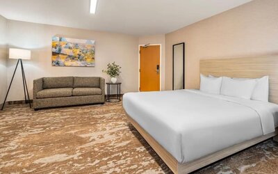 Spacious king guest room with sofa seating and contemporary décor at Comfort Inn Laval.
