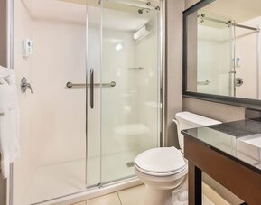 Modern guest bathroom with walk-in shower and contemporary vanity at Comfort Inn Laval.