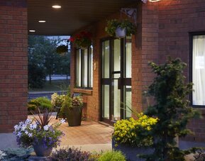 Welcoming front entrance surrounded by landscaped gardens at Comfort Inn Laval.