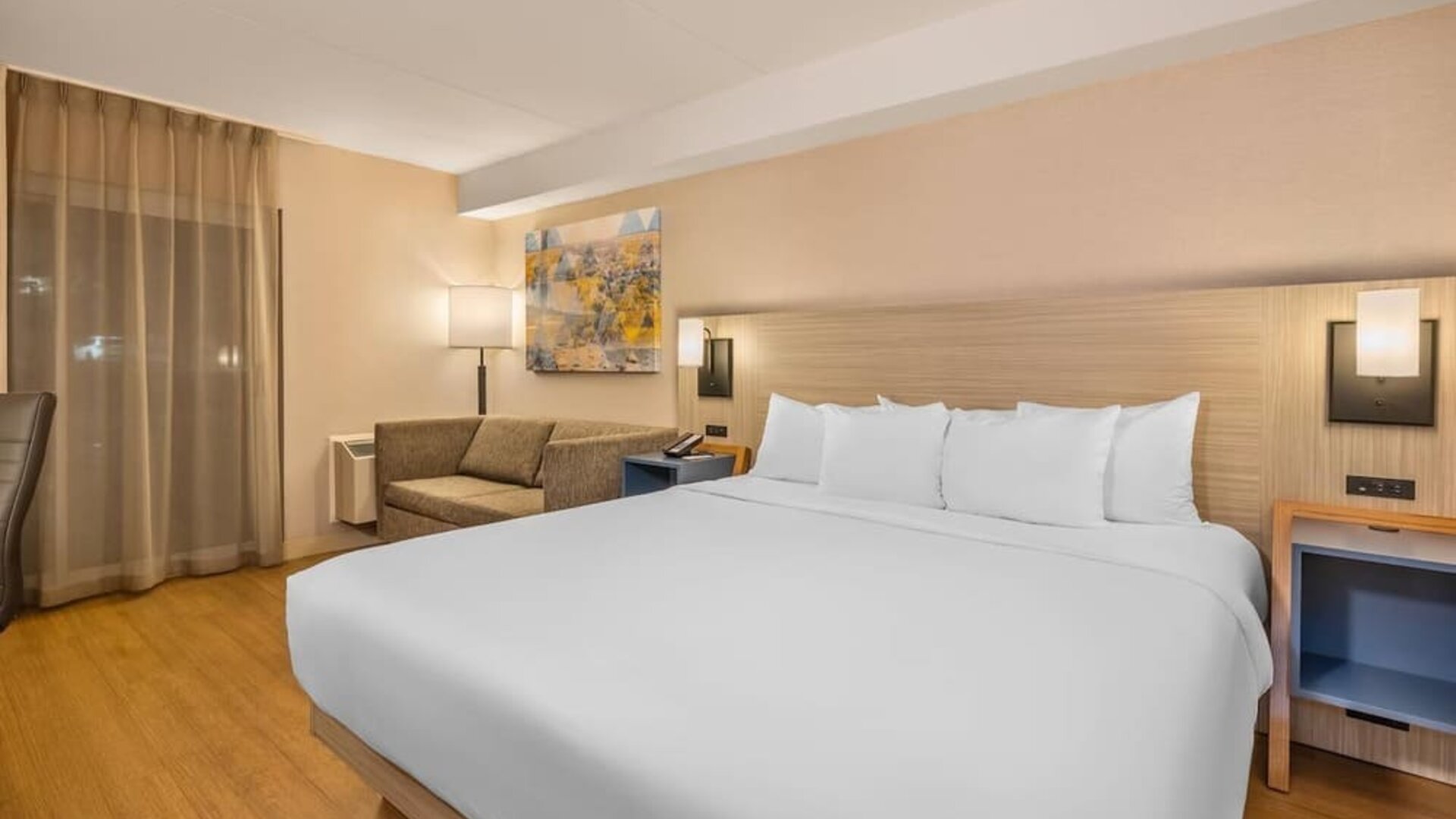 Comfortable king guest room with sofa seating and modern amenities at Comfort Inn Laval.