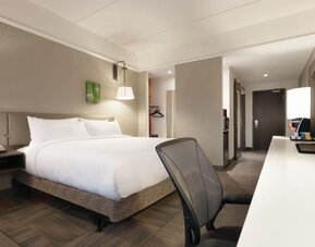 Contemporary king guest room with ergonomic workspace, HDTV and modern amenities at Hilton Garden Inn Calgary Downtown.