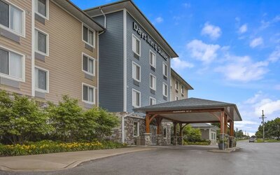 Exterior view of Days Inn & Suites By Wyndham Lindsay with landscaped entrance and covered driveway.
