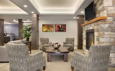 Inviting hotel lobby with fireplace, comfortable lounge seating and relaxing gathering space at Days Inn & Suites By Wyndham Lindsay.