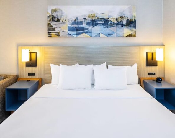 Inviting king bed with premium linens and modern bedside lighting for a restful stay at Comfort Inn Sydney.