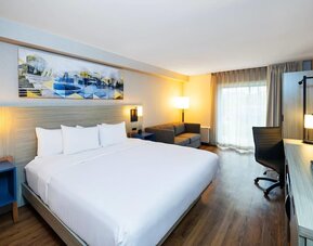 Comfortable king guest room featuring a bright workspace, sofa, and large flat-screen TV at Comfort Inn Sydney.