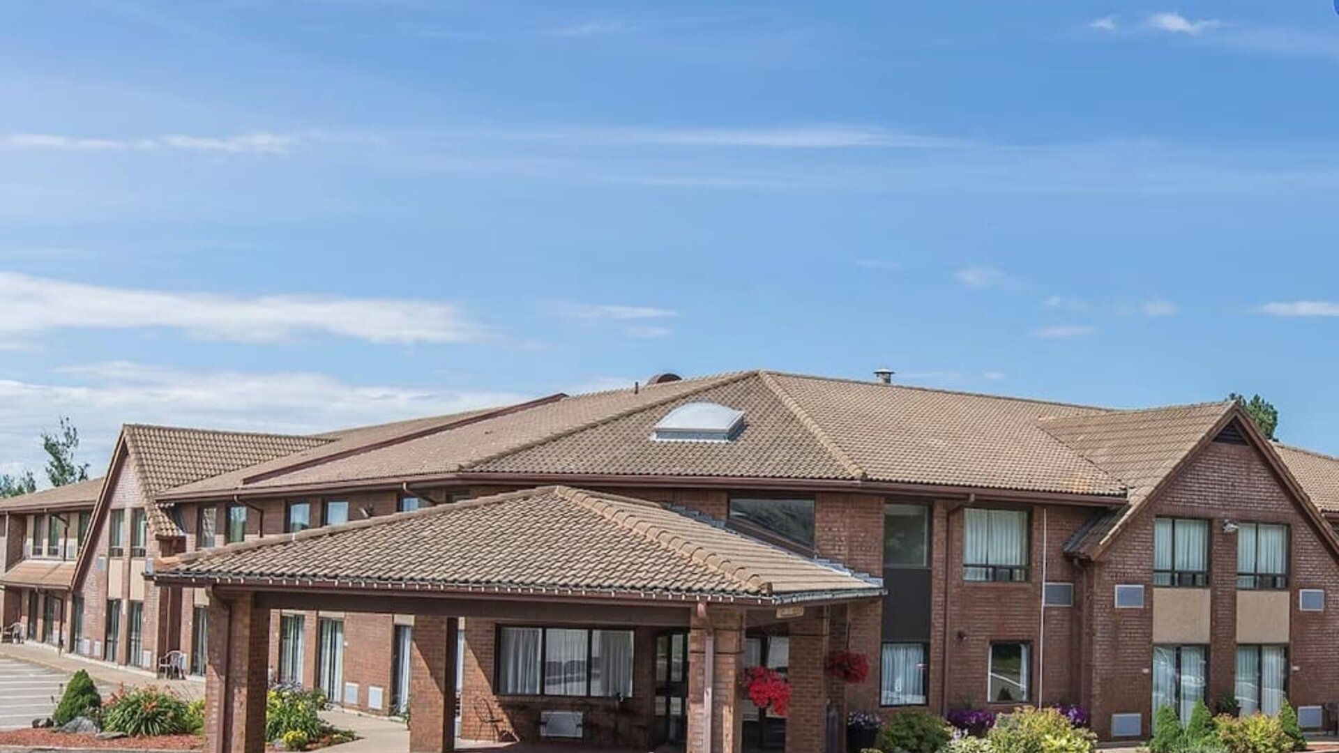 Exterior view of Comfort Inn Sydney showcasing convenient parking and covered hotel entrance.