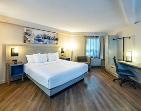 Spacious king guest room with plush bedding, ergonomic workspace, comfortable seating, and modern furnishings at Comfort Inn Amherst.