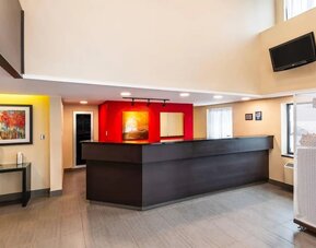 Spacious hotel lobby with modern reception desk, comfortable seating, and bright open design at Comfort Inn Amherst.