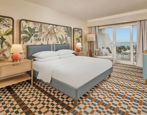 Elegant king guest room featuring plush bedding, private balcony, modern furnishings, and relaxing coastal-inspired décor at Hyatt Centric Delfina Santa Monica.