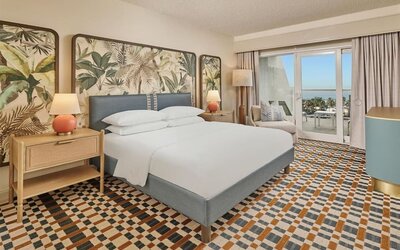 Elegant king guest room featuring plush bedding, private balcony, modern furnishings, and relaxing coastal-inspired décor at Hyatt Centric Delfina Santa Monica.