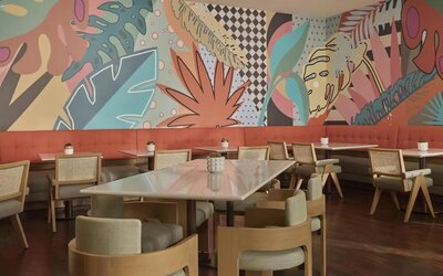 Contemporary hotel dining area with stylish seating, vibrant décor, and an inviting atmosphere for breakfast, lunch, and dinner at Hyatt Centric Delfina Santa Monica.