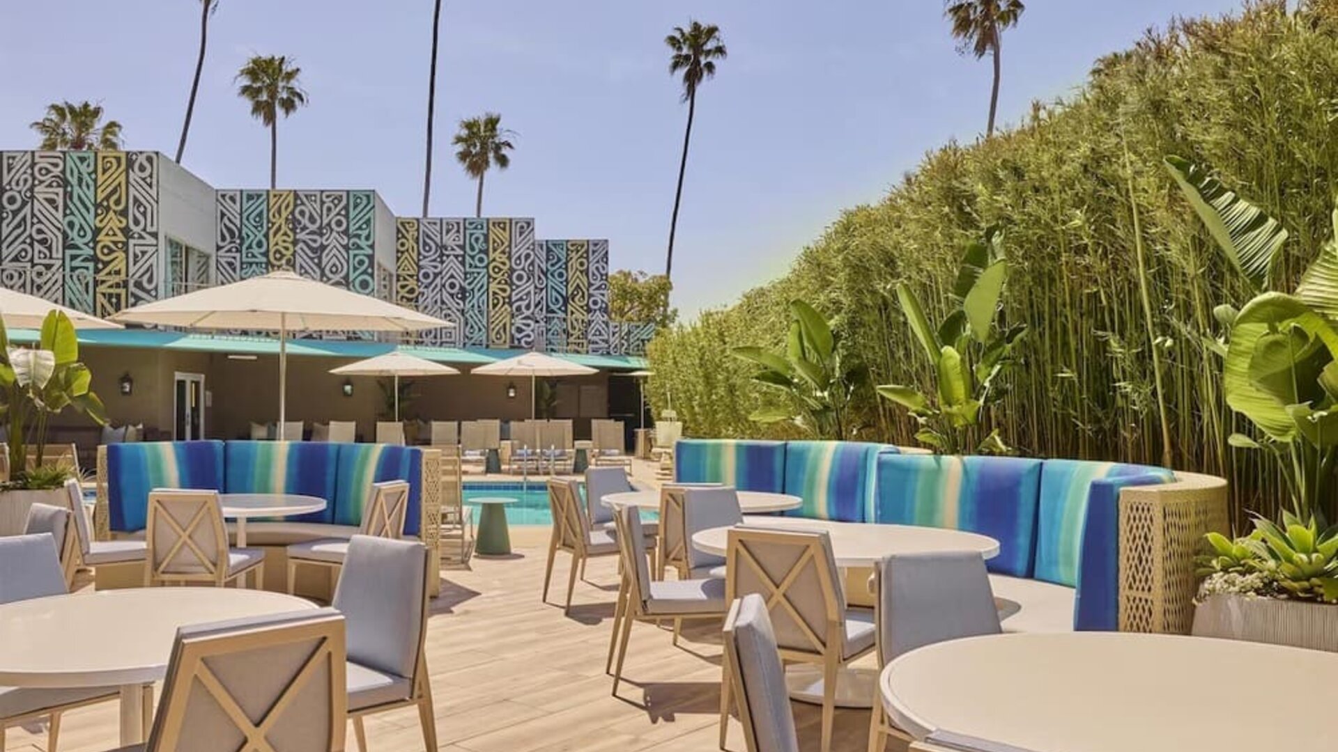 Outdoor poolside patio with comfortable seating, dining tables, and relaxing spaces to enjoy the Southern California sunshine at Hyatt Centric Delfina Santa Monica.