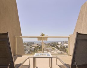 Private guest room balcony with comfortable seating and scenic views of Santa Monica and the Pacific coastline at Hyatt Centric Delfina Santa Monica.