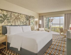 Bright king guest room featuring plush bedding, private balcony, ergonomic workspace, and contemporary coastal-inspired décor at Hyatt Centric Delfina Santa Monica.