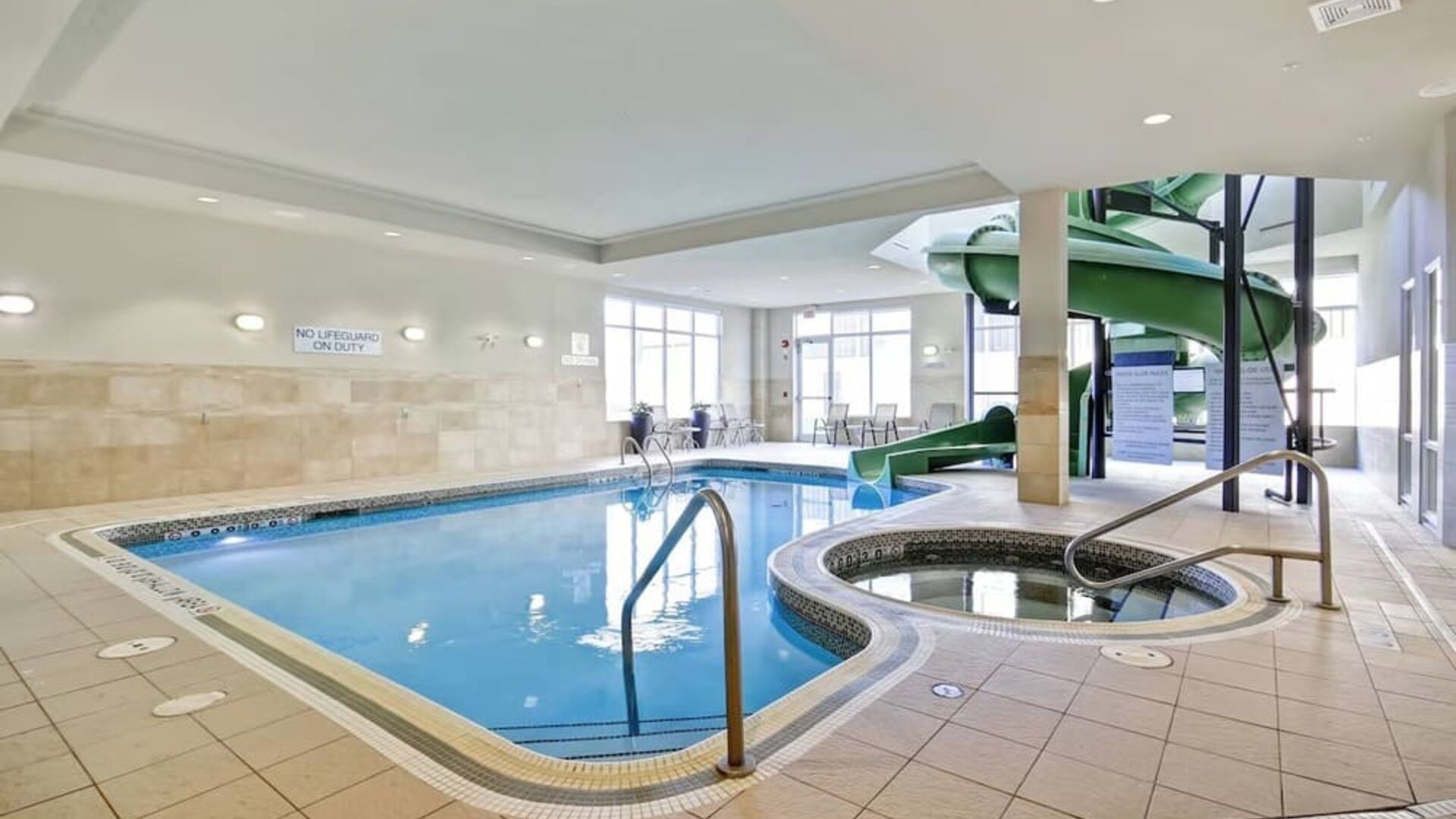 Indoor swimming pool with a hot tub and waterslide for family-friendly recreation at Fairfield Inn & Suites Guelph.