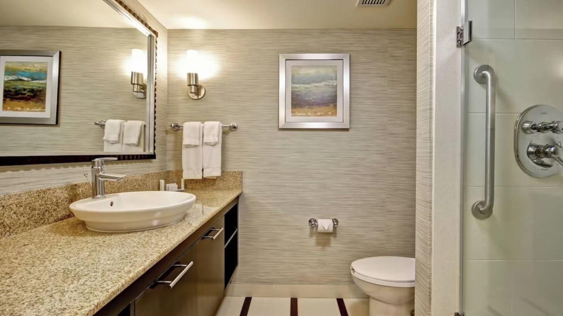 Modern accessible bathroom with a walk-in glass shower, granite vanity, and premium amenities at Fairfield Inn & Suites Guelph.