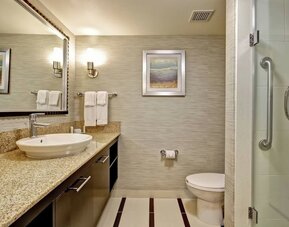 Modern accessible bathroom with a walk-in glass shower, granite vanity, and premium amenities at Fairfield Inn & Suites Guelph.