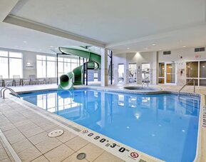 Spacious indoor pool featuring a waterslide, hot tub, and relaxing lounge area at Fairfield Inn & Suites Guelph.