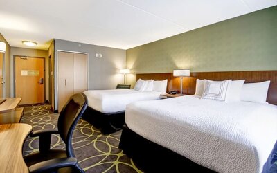 Spacious guest room with two queen beds, work desk, and contemporary furnishings at Fairfield Inn & Suites Guelph.