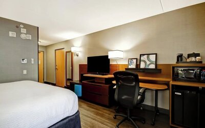 Contemporary king guest room with a spacious work desk, mini fridge, microwave, and flat-screen TV at Fairfield Inn & Suites Guelph.