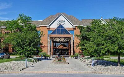 Welcoming hotel entrance surrounded by landscaped gardens at Four Points by Sheraton St. Catharines Niagara Suites.