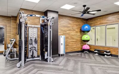 Fully equipped fitness centre featuring strength training equipment and functional workout space at Four Points by Sheraton St. Catharines Niagara Suites.