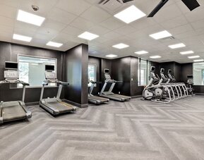Spacious fitness centre featuring cardio machines and strength training equipment at Four Points by Sheraton St. Catharines Niagara Suites.