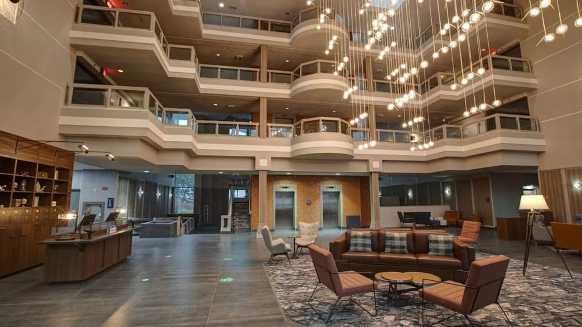Contemporary atrium lobby with stylish seating, open architecture, and modern lighting at Four Points by Sheraton St. Catharines Niagara Suites.