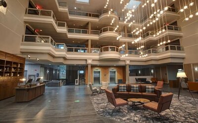 Contemporary atrium lobby with stylish seating, open architecture, and modern lighting at Four Points by Sheraton St. Catharines Niagara Suites.