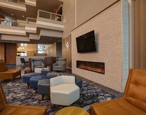 Cozy lobby lounge featuring a fireplace, comfortable seating, and a relaxing atmosphere at Four Points by Sheraton St. Catharines Niagara Suites.