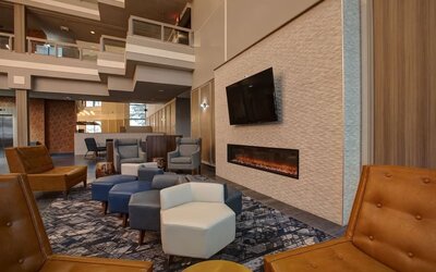 Cozy lobby lounge featuring a fireplace, comfortable seating, and a relaxing atmosphere at Four Points by Sheraton St. Catharines Niagara Suites.