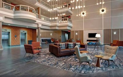 Bright atrium lobby with contemporary seating areas and elegant lighting at Four Points by Sheraton St. Catharines Niagara Suites.