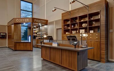 Reception desk with adjacent coffee pantry and convenience market at Four Points by Sheraton St. Catharines Niagara Suites.