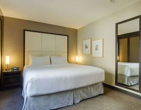 Contemporary guest room featuring a plush king bed, premium linens, and modern furnishings at ARC The Hotel Ottawa.