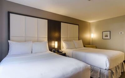 Comfortable guest room with two beds, premium bedding, and modern amenities for families or groups at ARC The Hotel Ottawa.