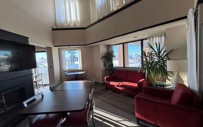 Bright lobby lounge with comfortable seating, dining tables, and a relaxing atmosphere at Comfort Inn Baie-Comeau.