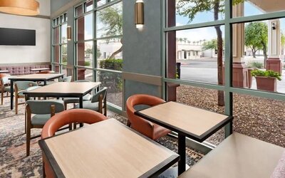Bright dining area with comfortable seating and floor-to-ceiling windows, perfect for breakfast, coffee, or casual meals at Hyatt Place Scottsdale/Old Town.