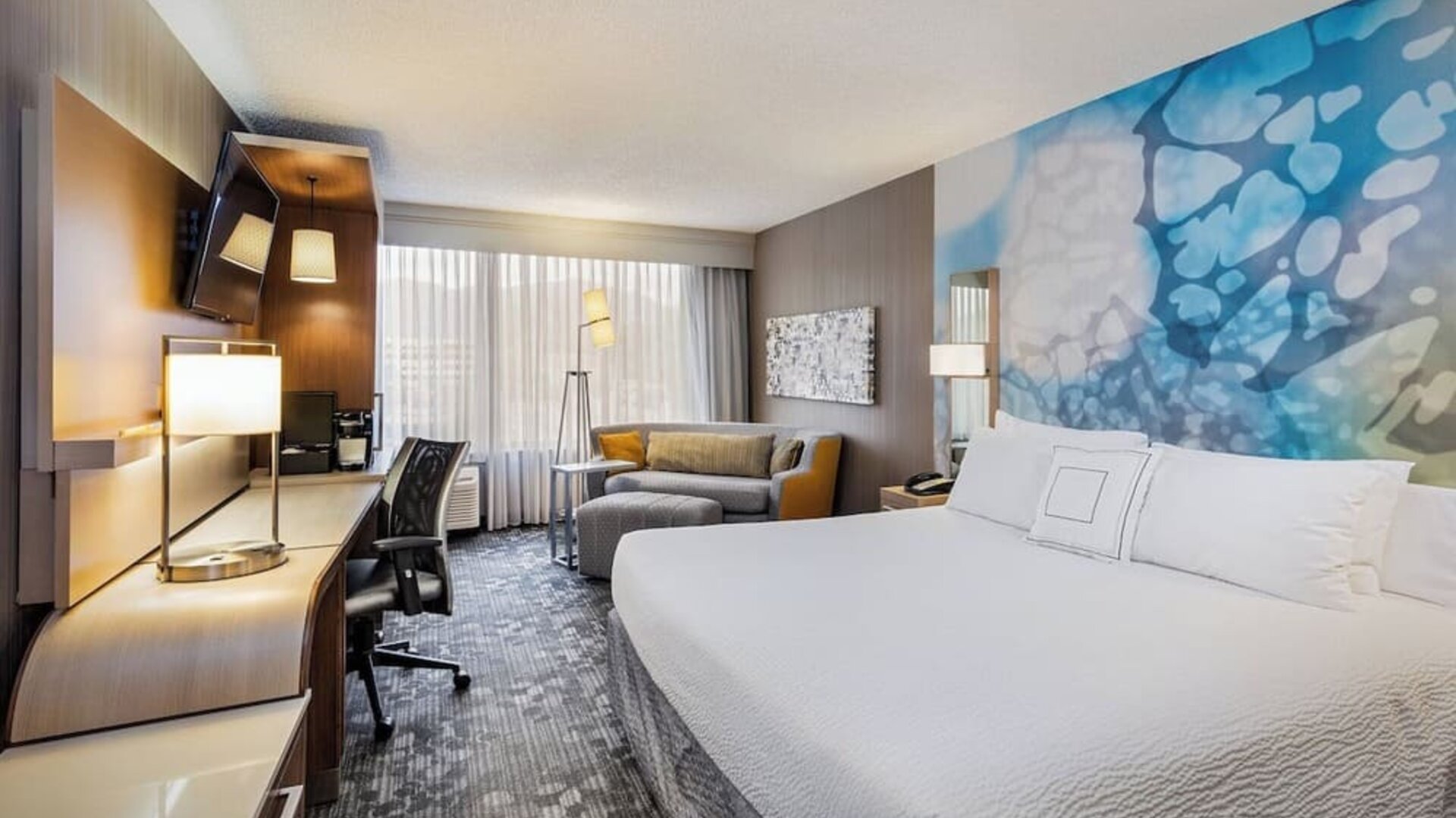 Spacious king guest room with a plush king bed, comfortable seating area, ergonomic workspace, and modern amenities at Courtyard Riverside UCR/Moreno Valley Area.