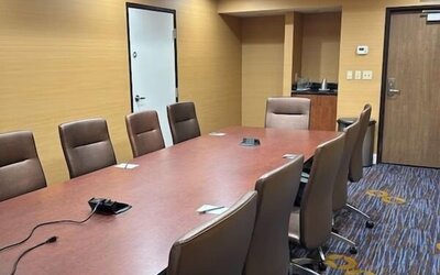 Private boardroom with conference table, ergonomic seating, and presentation connectivity for business meetings at Courtyard Riverside UCR/Moreno Valley Area.