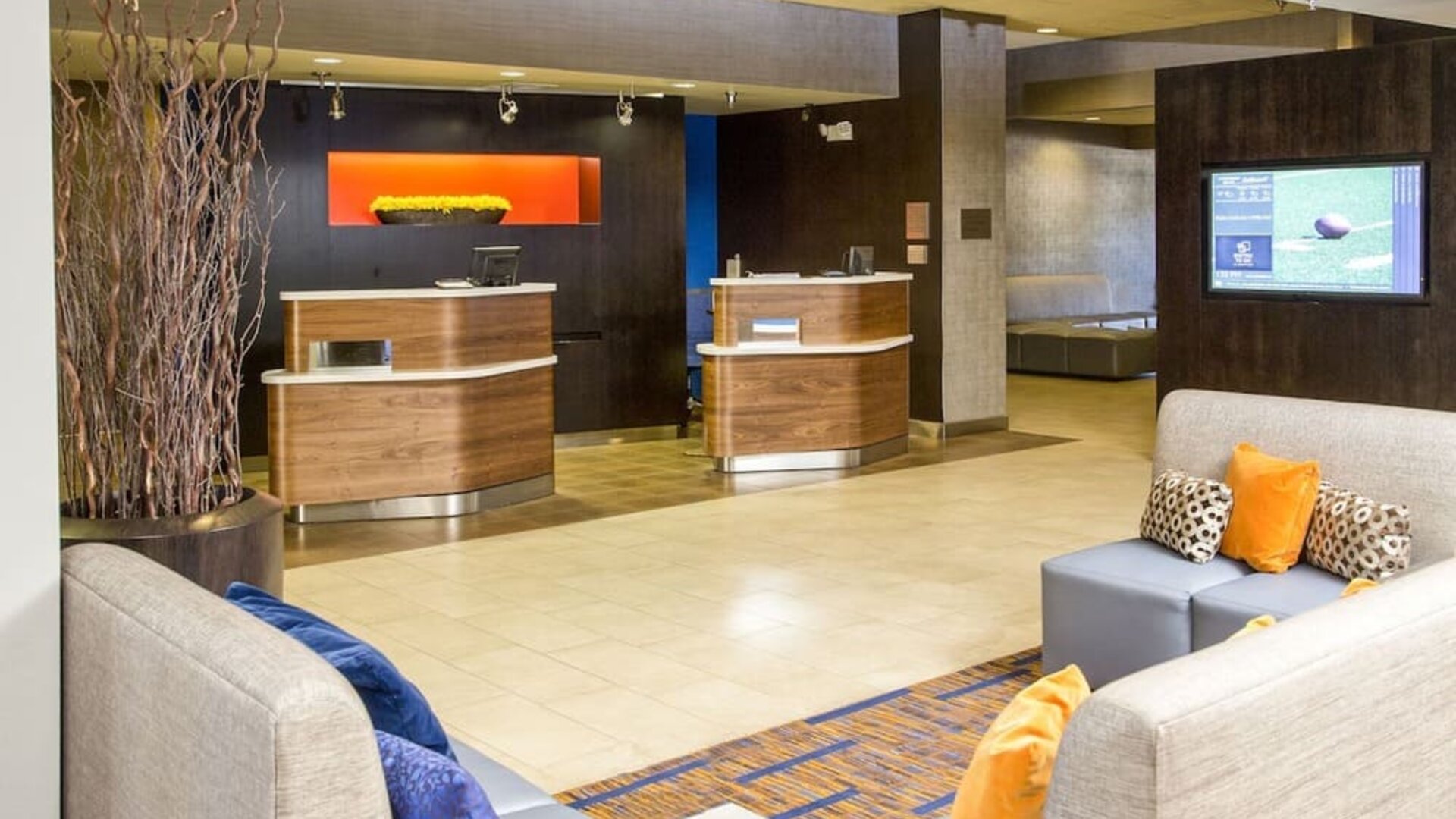 Reception area with modern check-in desks and a welcoming lobby entrance at Courtyard Riverside UCR/Moreno Valley Area.