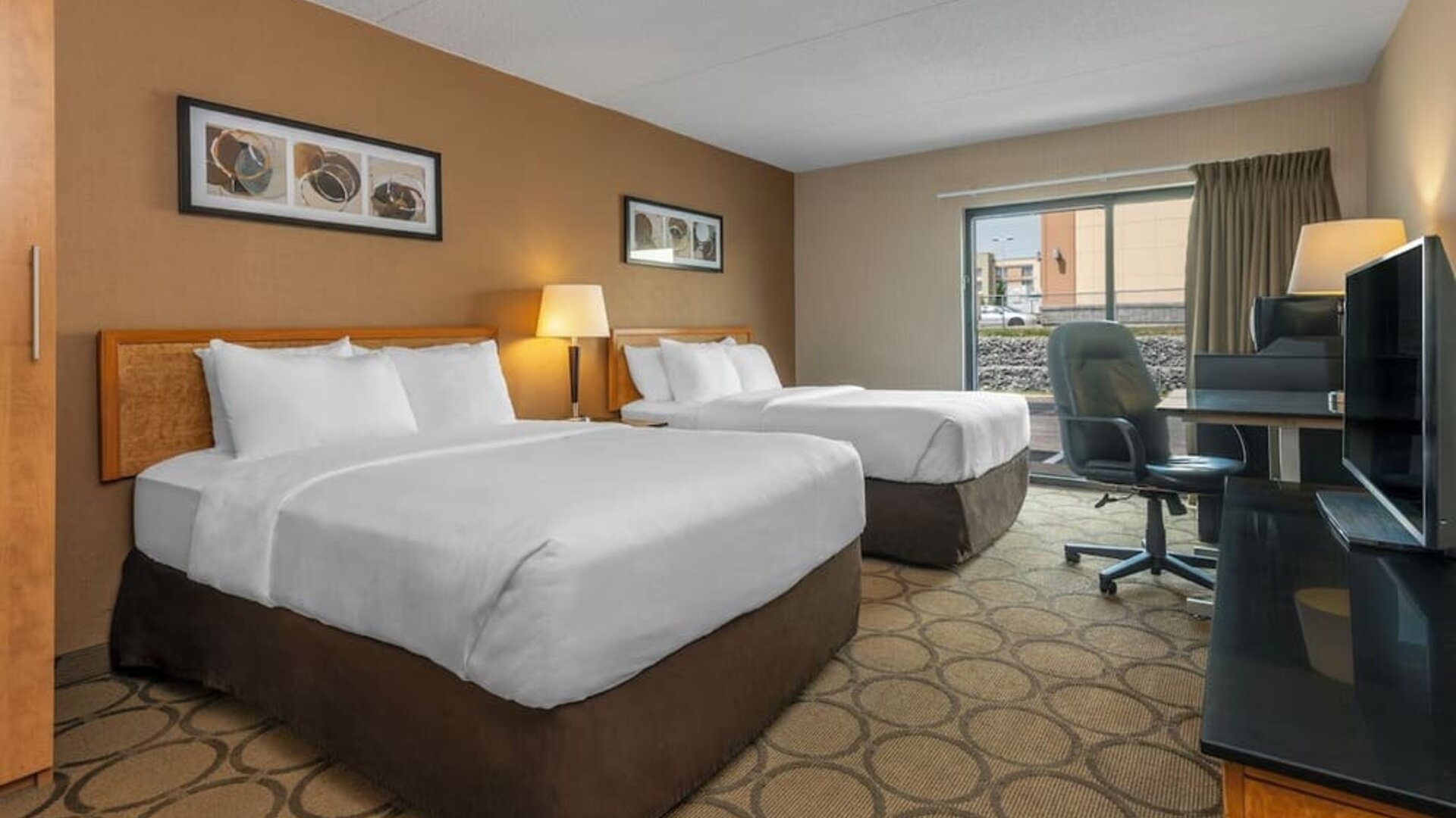 Guest room featuring two comfortable double beds, a spacious work desk, HDTV, and modern accommodations at Comfort Inn Sherbrooke.