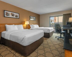 Guest room featuring two comfortable double beds, a spacious work desk, HDTV, and modern accommodations at Comfort Inn Sherbrooke.