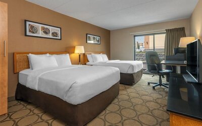 Guest room featuring two comfortable double beds, a spacious work desk, HDTV, and modern accommodations at Comfort Inn Sherbrooke.