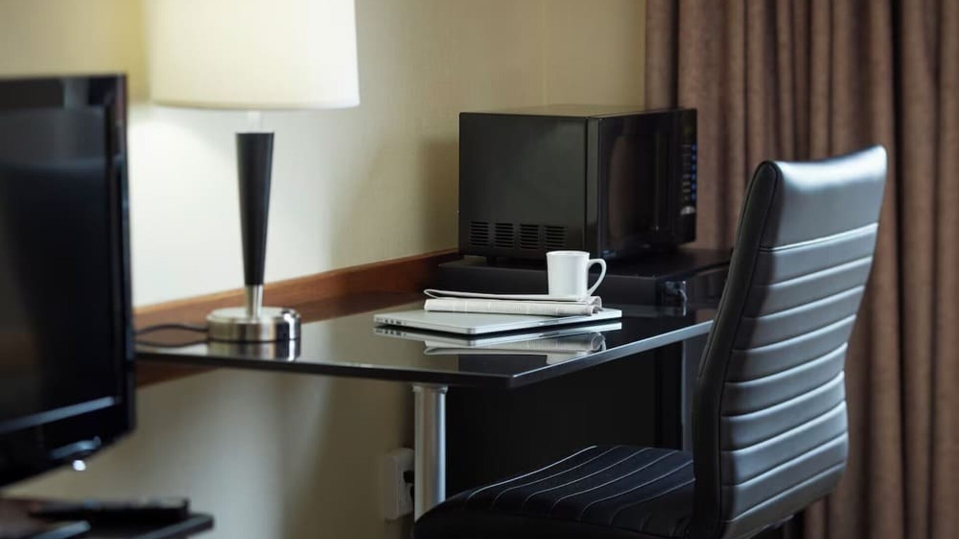 In-room workspace with a desk, ergonomic chair, microwave, mini refrigerator, and coffee service at Comfort Inn Sherbrooke.