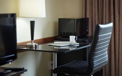 In-room workspace with a desk, ergonomic chair, microwave, mini refrigerator, and coffee service at Comfort Inn Sherbrooke.