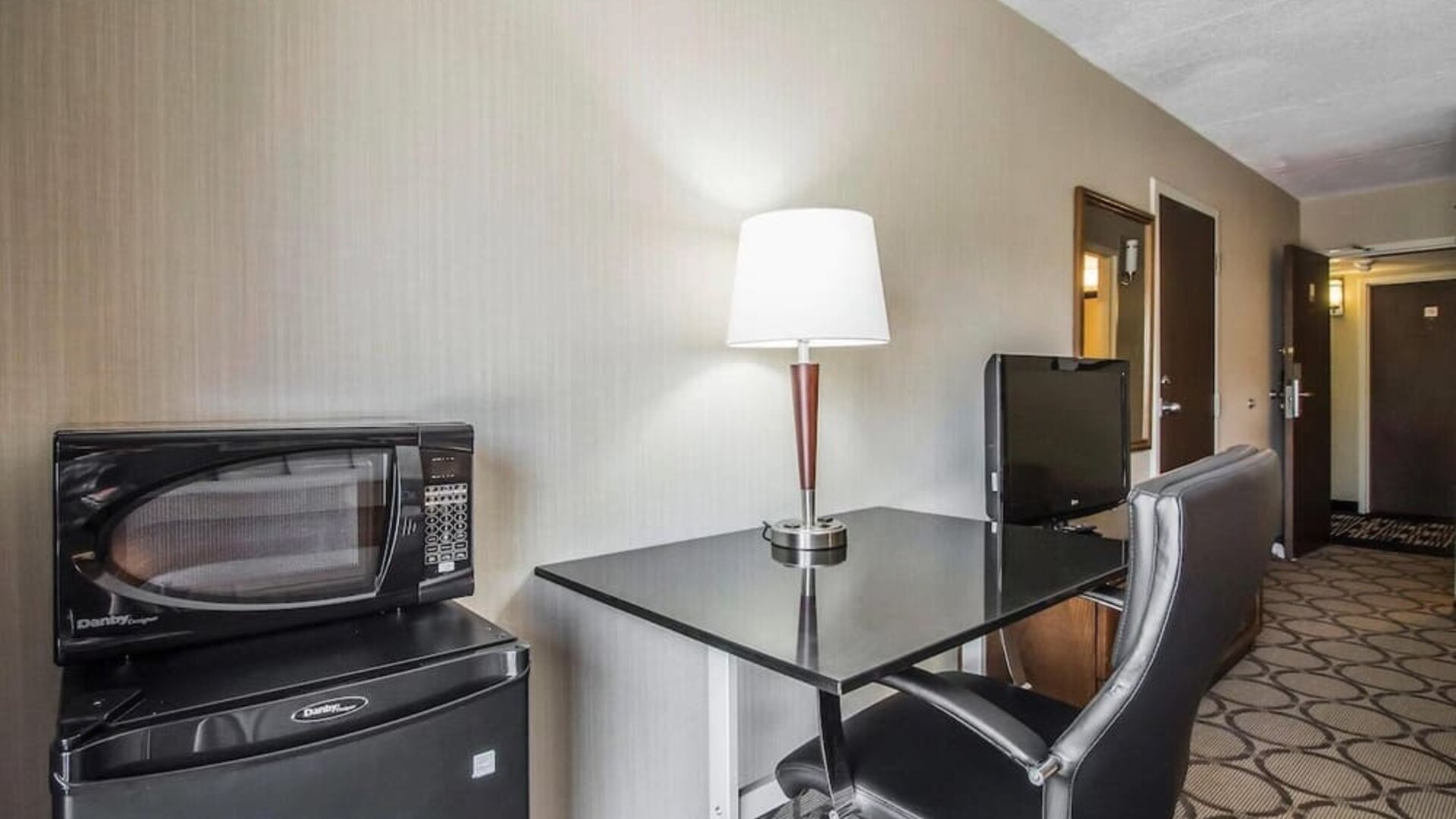 In-room workspace featuring a desk, ergonomic chair, microwave, mini refrigerator, and coffee service at Comfort Inn Sherbrooke.