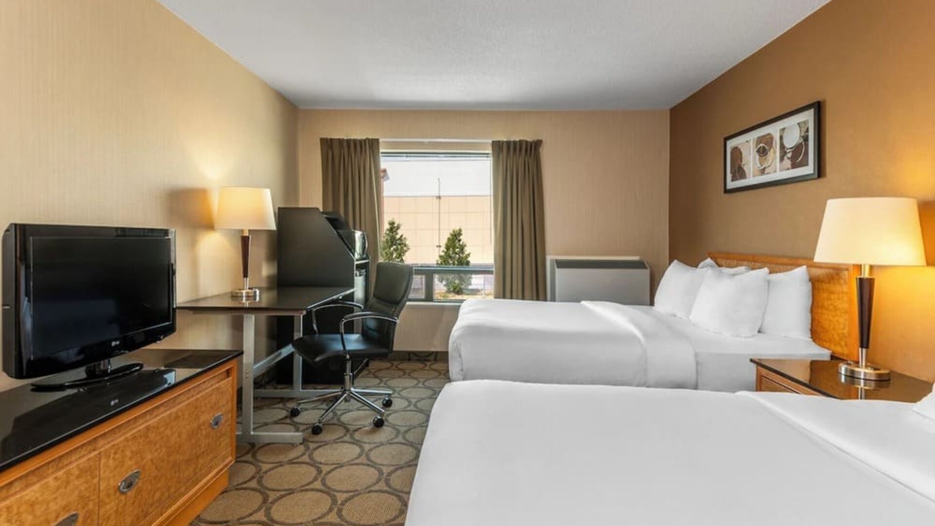 Guest room with two double beds, a work desk, HDTV, and convenient in-room amenities at Comfort Inn Sherbrooke.