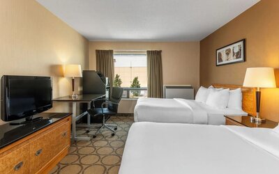 Guest room with two double beds, a work desk, HDTV, and convenient in-room amenities at Comfort Inn Sherbrooke.