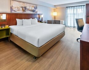 Spacious king guest room with a work desk, seating area, and contemporary furnishings at Comfort Inn Sudbury East.