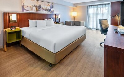 Spacious king guest room with a work desk, seating area, and contemporary furnishings at Comfort Inn Sudbury East.